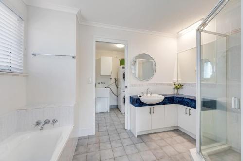 a bathroom with a tub and a sink and a shower at Seychelle unit 5 Kings Beach in Caloundra