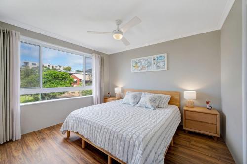 a bedroom with a bed and a large window at Seychelle unit 5 Kings Beach in Caloundra