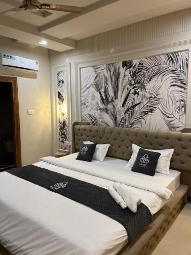 Ein Schlafzimmer mit zwei Betten und schwarz-weißer Tapete in der Unterkunft Hotel H Plus in Kurukshetra