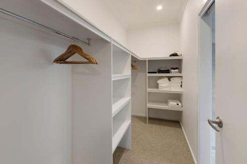 a walk in closet with white shelves and a door at Timber Mill Cottage - Mansfield in Mansfield
