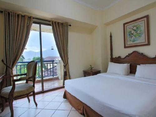a bedroom with a large bed and a balcony at Marbella Place Anyer by Jayakarta in Kamasan