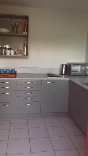 cocina con armarios blancos y encimera en Ocean View Self-contained Apartment en Porirua