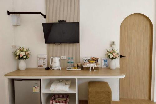 a room with a desk with a television on a wall at Chertam Le Marjestic Hotel โรงแรม เฌอแตม ลำปาง in Ban Kat Mek