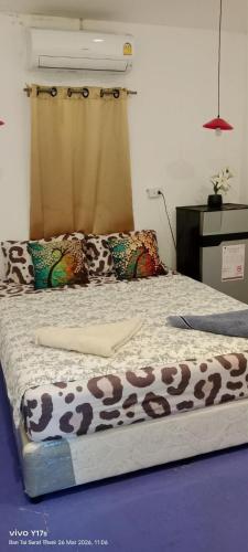 a bed with a cow blanket on top of it at 3 Star and the Sun in Ban Nua