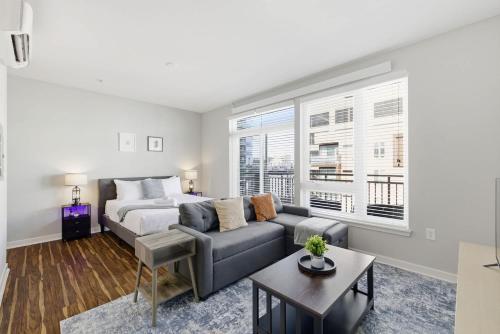 a living room with a bed and a couch at CozySuites at Artistry Indianapolis in Indianapolis