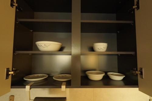 a display cabinet with bowls and plates on it at Sunset Stay Osong in Ch'ŏngnyong