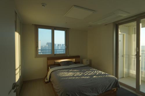 a bedroom with a bed and a window at Sunset Stay Osong in Ch'ŏngnyong