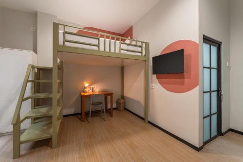 a room with a bunk bed and a table and a desk at Cove Haven in Surabaya
