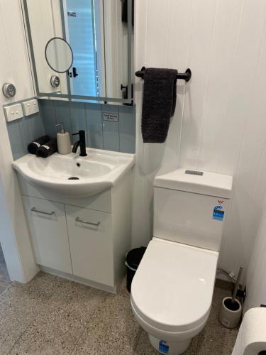 a bathroom with a white toilet and a sink at The Barn Top Noojee in Noojee