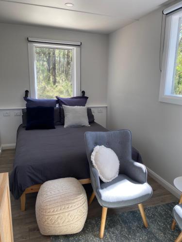 a bedroom with a bed and a chair and a window at The Barn Top Noojee in Noojee