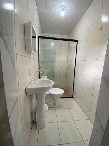 a white bathroom with a toilet and a sink at Aluguel por temporada Triunfo-PE in Triunfo