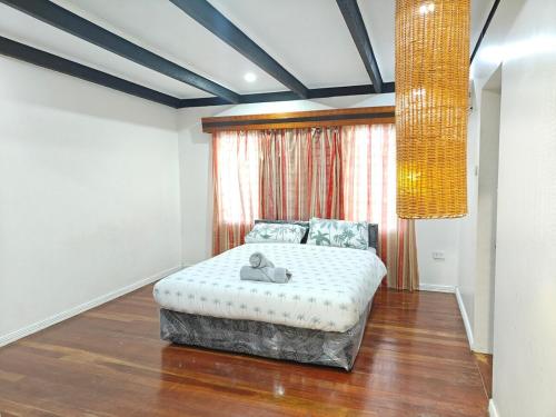 a bedroom with a bed and a large window at 3 bedroom fully air conditioned family home -spacious, free parking in Suva