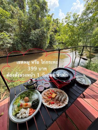 a grill with plates of food on a table at Amornkeeree Khao Sok Camping in Khao Sok National Park