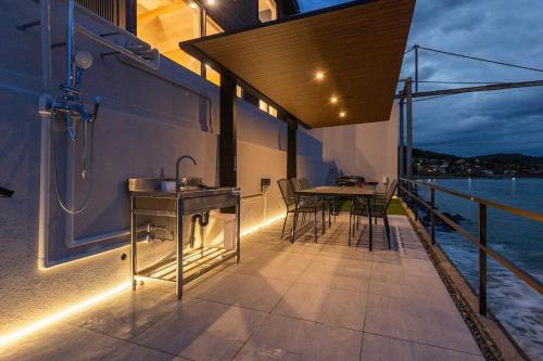 a balcony with a shower and a table and chairs at Namioto Villa YOSA in Hama