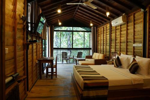 a bedroom with a bed and a living room at The Glenrock Wellness Nature Resort in Belihuloya
