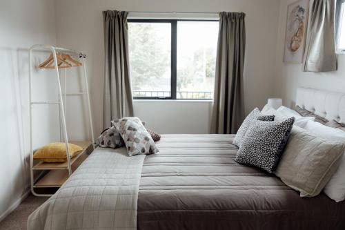 a bedroom with a large bed with a large window at Pembroke View in Carterton