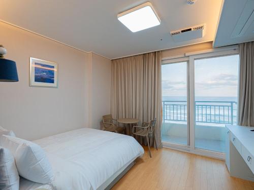 a bedroom with a bed and a view of the ocean at 블루앤호텔 in Songjŏng