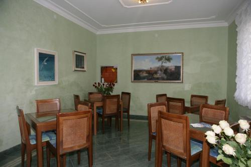 a dining room with wooden tables and chairs at Hotel Villa Rosa in Grado