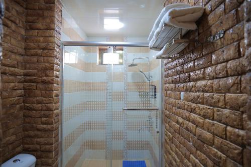 a bathroom with a shower with a glass door at Golubie Kupola Hotel 华人酒店 in Bukhara