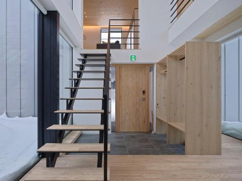a wooden staircase in a room with wooden walls at TsuTsu Furano by H2 Life in Furano