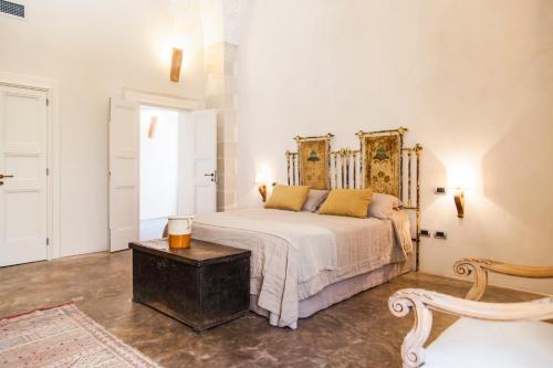 a bedroom with a bed and a table at Antica Dimora Giardini Segreti in Giuggianello