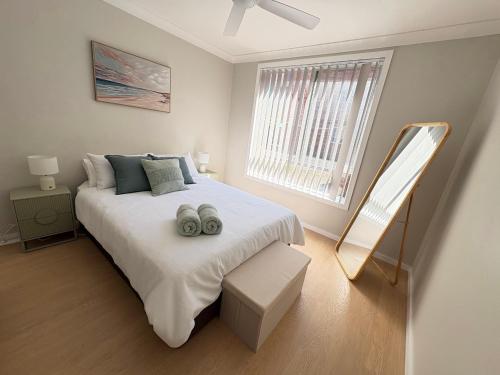 a bedroom with a large bed and a window at Melrose Place at Flynn's Beach in Port Macquarie
