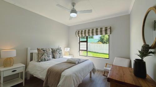 a bedroom with a bed and a table and a window at The Dock in Clarens