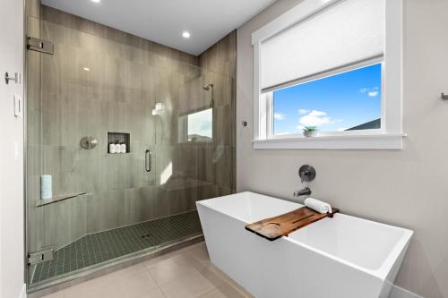 a bathroom with a shower and a white tub at The Oceanview Retreat in Westport