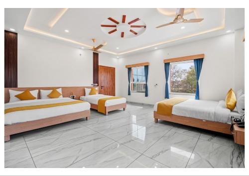 a bedroom with two beds and a ceiling fan at RS Resort in Ayodhya