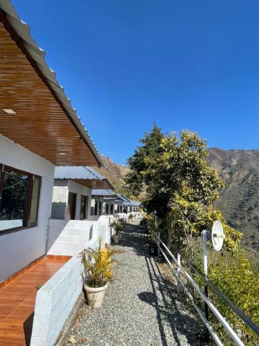 a building with a pathway next to a mountain at ITW - Into The Wild , Viratkhai , Chakrata in Lakhwār