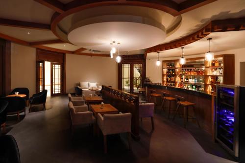 a restaurant with tables and chairs and a bar at Amba Paro in Paro