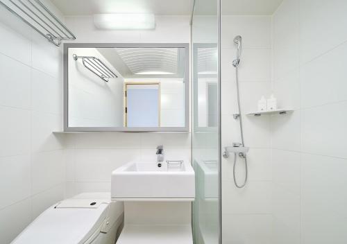 a white bathroom with a sink and a shower at Hanwha Resort Daecheon Paros in Boryeong