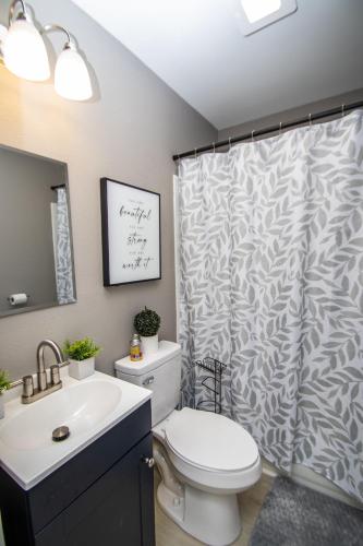 a bathroom with a toilet and a shower curtain at Home Sweet Home Bungalow in North Little Rock