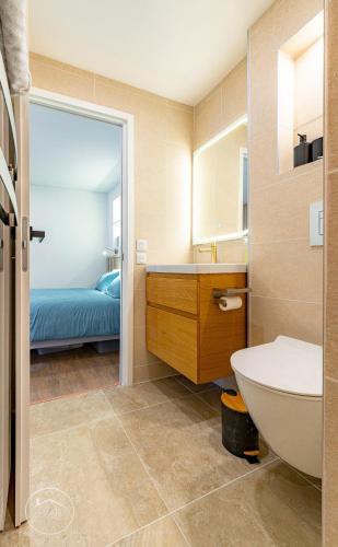 a bathroom with a sink and a toilet and a bed at Studio neuf et moderne centre historique in Chambéry