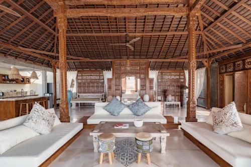 a large living room with white couches and tables at Dolce Vita Villa in Sampalan