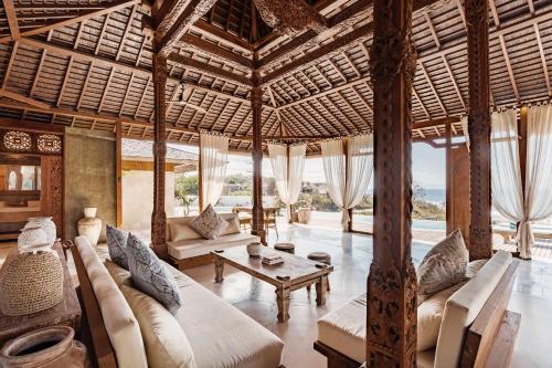 a living room with a large wooden ceiling at Dolce Vita Villa in Sampalan