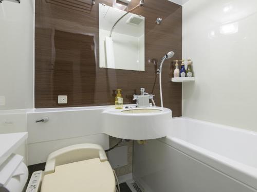 a white bathroom with a sink and a mirror at Onomichi Daiichi Hotel in Onomichi