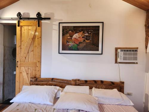 a bed in a room with a picture on the wall at Guarin House in Sipating