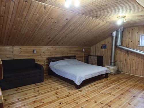 a bedroom with a bed in a wooden room at Гостьовий будинок з банею in Bohuslav