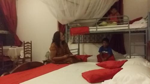 a woman and child sitting on a bed in a bedroom at Sunset Beach Residence in Panadura