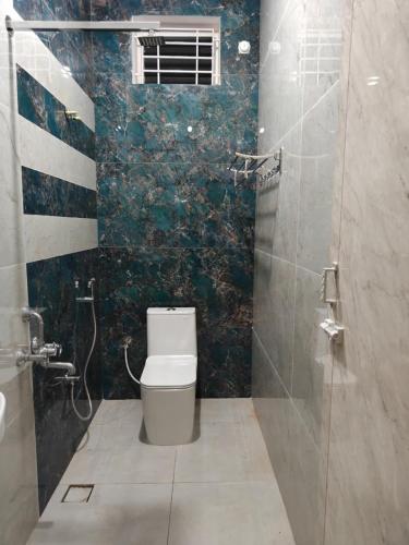 a bathroom with a toilet and a shower at TADY Homes in Tiruvannāmalai
