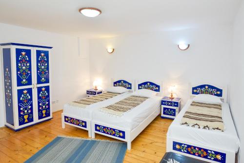 two beds in a room with blue and white at Pension Bassen in Bazna
