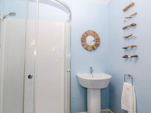 a bathroom with a shower and a sink at Bwthyn y Mor in Porthmadog