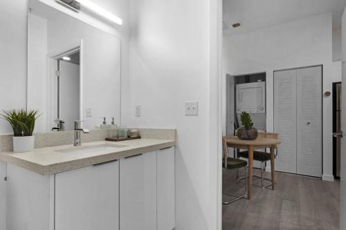a white bathroom with a sink and a table at Voy House Wynwood with Rooftop Pool in Miami