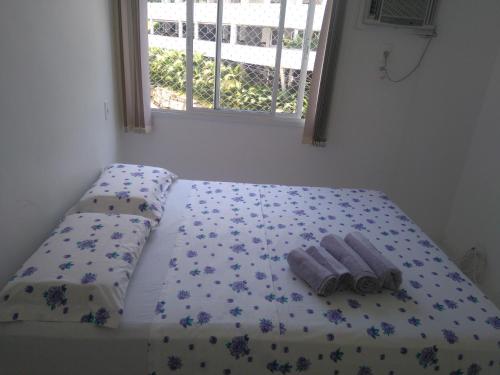 a bed with two towels on it with a window at Apartamento Aconchegante Porto Real Resort Mangaratiba in Mangaratiba