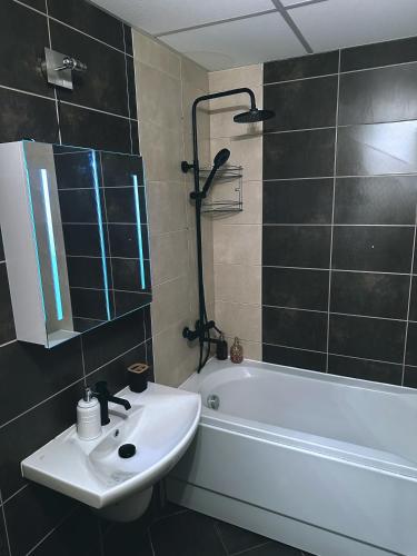 a bathroom with a sink and a bath tub at Aspen Pirin View in Razlog