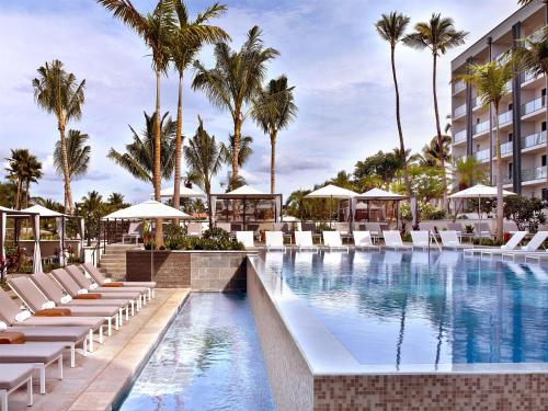 a pool at the resort with lounge chairs and palm trees at Andaz Maui at Wailea Resort - A Concept by Hyatt in Wailea
