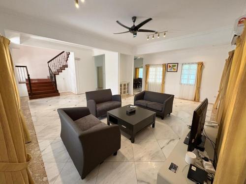 a living room with two couches and a television at Tiara Labuan Hotel in Labuan