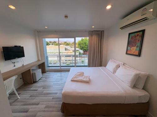 a bedroom with a large bed and a television at Nantra Hua Hin in Hua Hin