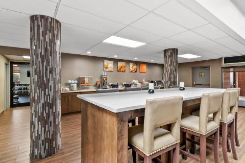 a large kitchen with a large island with chairs around it at Comfort Suites Near Potomac Mills in Woodbridge